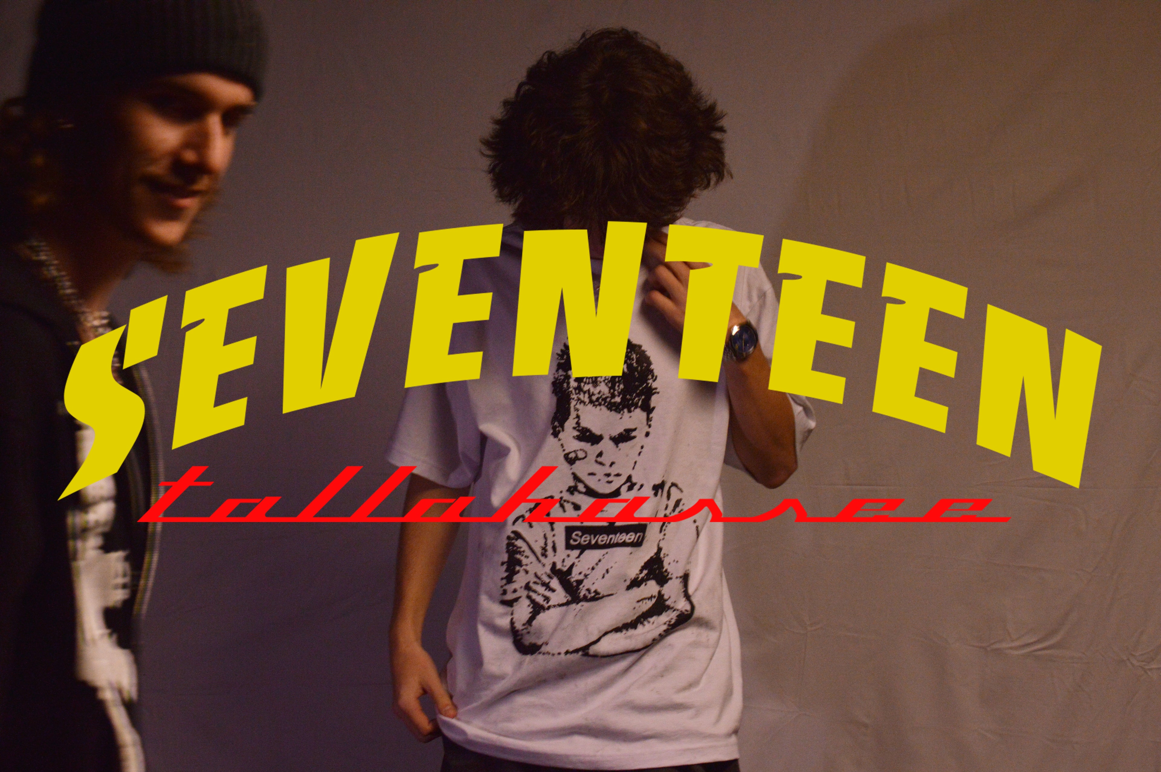 Person wearing a 'SEVENTEEN' t-shirt with a graphic design on a plain background